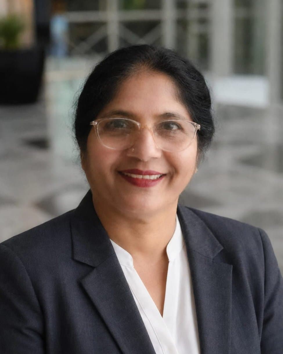 Tejashri Gaonkar smiling, in a dark blazer and white blouse